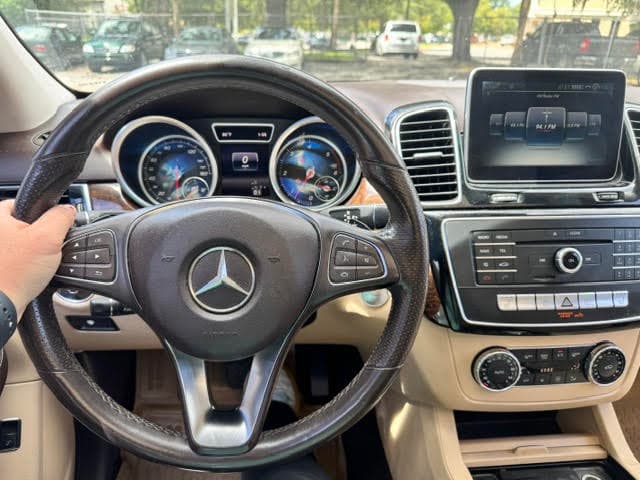 View from the driver's seat of a Mercedes-Benz — steering wheel, instrument cluster and center touchscreen